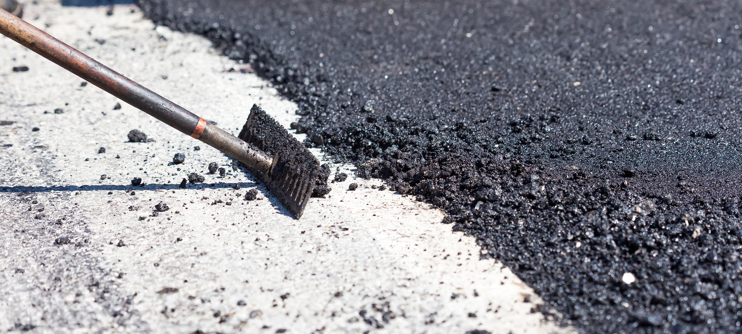 Workers making asphalt with rakes