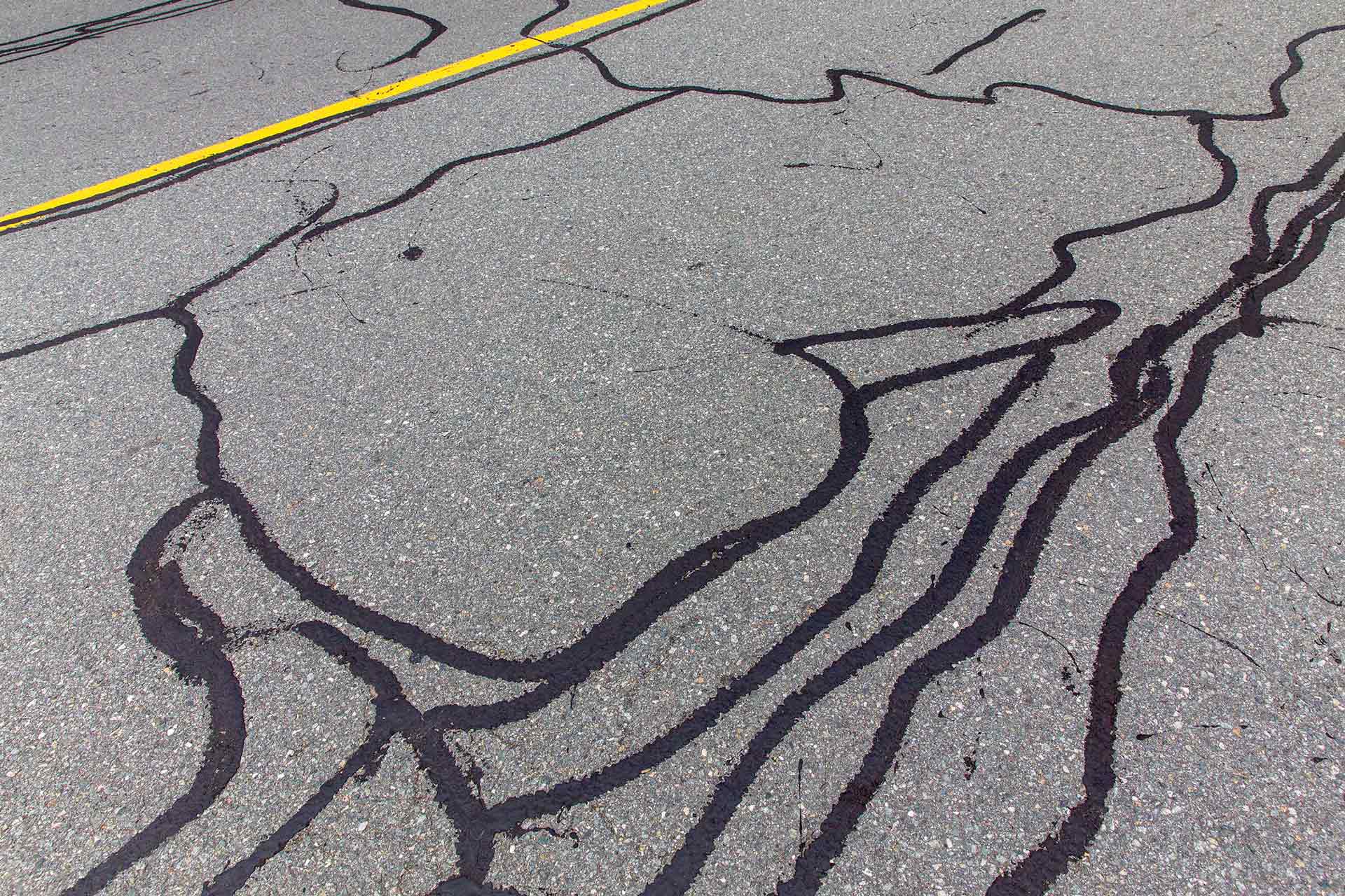 Cracks on asphalt road being repaired
