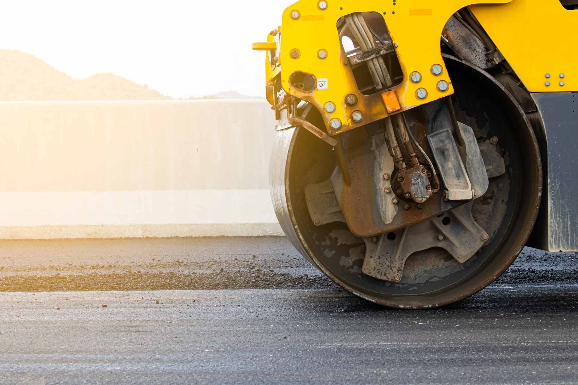 Asphalt road surface is smoothed with steel wheels